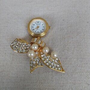 Cenere: Quartz brooch watch with faux pearls and rhinestones.